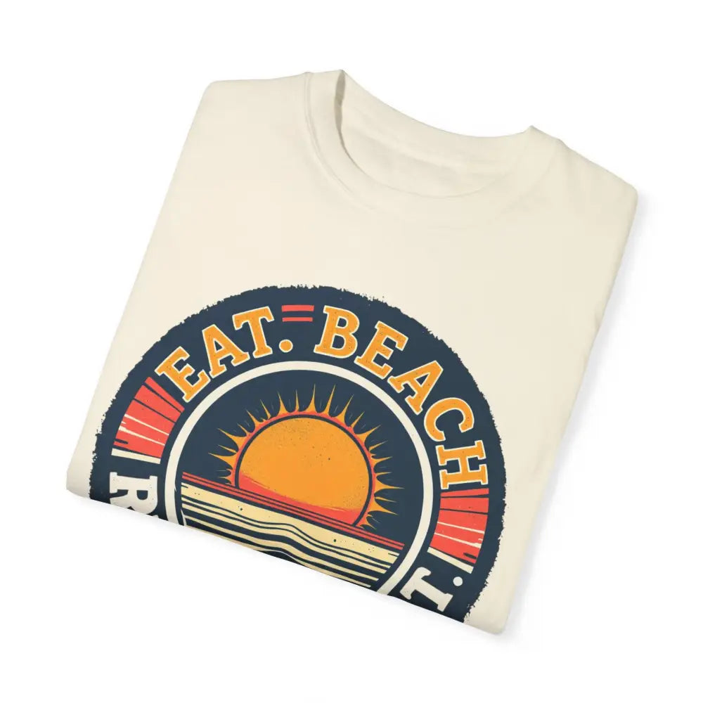 Folded cream-colored t-shirt with beach graphic from Island Reef Eat Beach Relax Repeat Tee