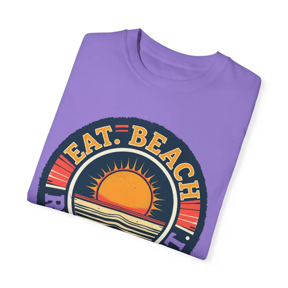 Folded purple t-shirt with beach graphic from Island Reef Eat Beach Relax Repeat Tee