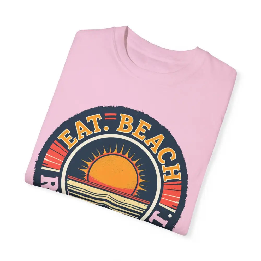 Folded pink Island Reef Unisex Garment Dyed Eat Beach Relax Repeat Tee displayed elegantly