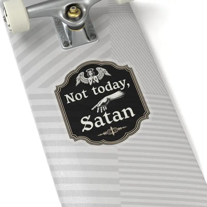 Skateboard featuring Not Today Satan sticker alongside decorative sign in black and gold