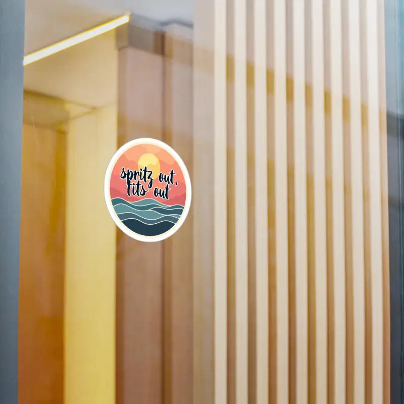 Round sticker featuring a sunset and ocean design for laptops