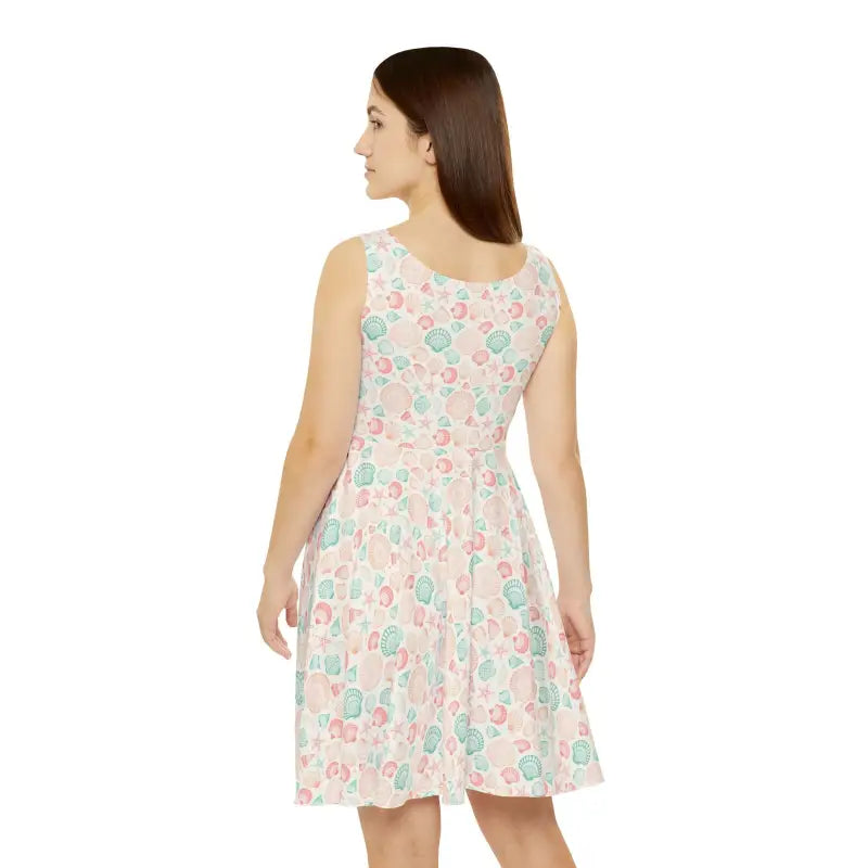 Woman wearing a sleeveless seashell-patterned dress for summer beach outings