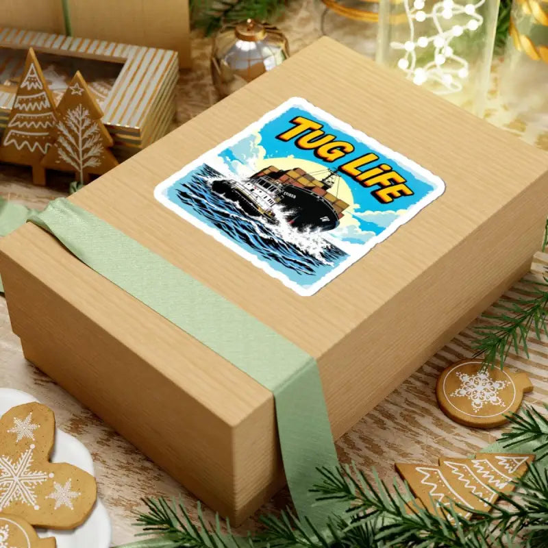 Wrapped gift box with Tug Life sticker featuring tugboat assisting container ship