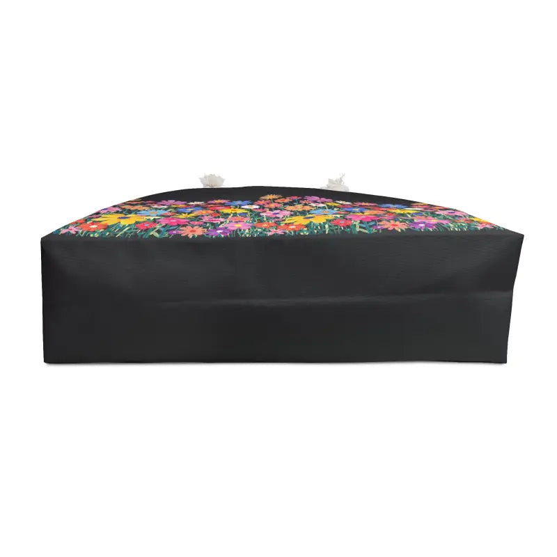 Black tote bag featuring a vibrant floral print, ideal for travel and weekend getaways